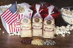 Hand holding a one‑pound bag of Amish Country Popcorn next to a measuring cup for size clarity