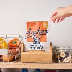 Archer Jerky pouch in hand demonstrating 2.5 oz scale and easy portability