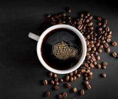 Black Insomnia Coffee cup next to measuring scoop and ruler for scale, illustrating portion control