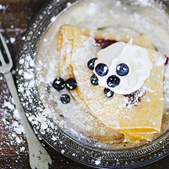 Blackberry Patch syrup being drizzled on pancakes for rich blueberry flavor