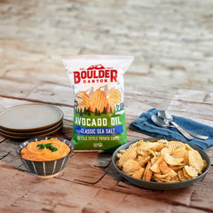 Boulder Canyon chip bag held in hand to show 5.25-ounce scale and convenience