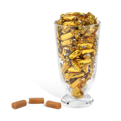 Candy Envy hand holding a single wrapped caramel, shows portable convenience and hygiene