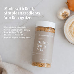 Clean Monday Meals jar beside fresh onions and garlic showing clean ingredients and culinary use