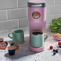 Crazy Cups pod being inserted into a Keurig-compatible brewer demonstrating easy single-serve use