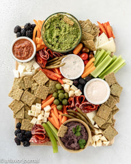 Crunchmaster crackers served with avocado and tomato toppings for tasty pairing