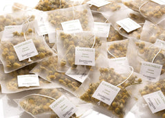 Dammann Freres Cristal sachet close-up revealing whole chamomile flowers and clear infusion