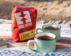 Equal Exchange decaf three-pack beside common household items showing scale and value