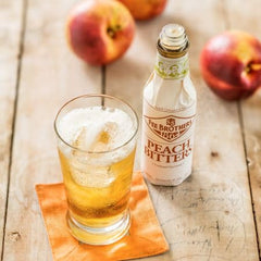 Fee Brothers bitters pouring into cocktail adding peach aroma and balanced taste