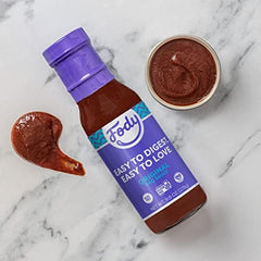 hand holding Fody Vegan BBQ Sauce bottle to show scale and convenient kitchen portioning