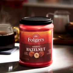 Open Folgers Toasty Hazelnut canister with spoon, demonstrates easy scooping and freshness
