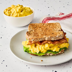 French's jar next to sandwiches and wraps showing meal-ready versatility