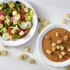 Fresh Gourmet croutons sprinkled on a Caesar salad demonstrating added texture and savory bite for meals