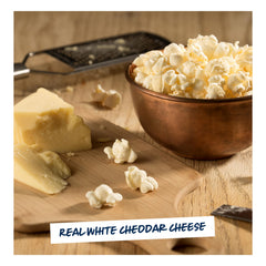 Hand holding a 5.0 oz Garrett Popcorn white cheddar bag to demonstrate true scale and single‑serve convenience