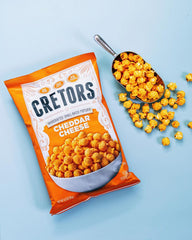 G.H. Cretors bag beside a measuring cup to show 6.5 oz size and portable convenience