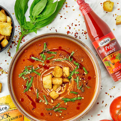 Grace hot pepper sauce close-up texture highlighting smooth pourable consistency and vibrant color