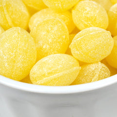 Hand holding one Claeys lemon drop from The Hampton Popcorn Company showing size and shape