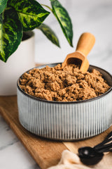 India Tree light muscovado in a wooden bowl beside baking utensils, adds deeper flavor to recipes
