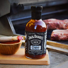 Jack Daniel's Old No.7 bottle in use brushing sauce on ribs for rich flavor finish