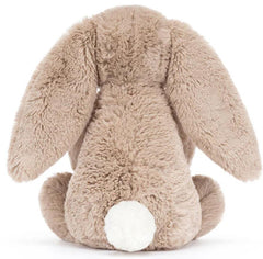 Jellycat Bashful Beige Bunny styled in a nursery setting beside crib — decorative and cuddly companion