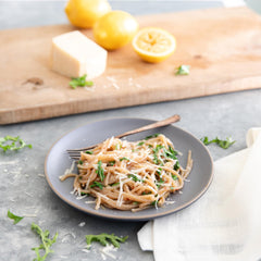 Jovial cooked cassava spaghetti plated with tomato sauce and fresh basil