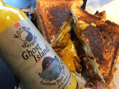 Karma Sauce Ghost Island being poured over chicken wings, adds tropical heat and savory lift