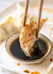 Kikkoman bottle beside plated potstickers illustrates serving suggestion and appetizing pairing