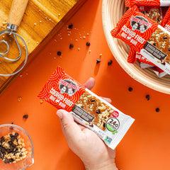 Lenny & Larry's bar held in hand to show 90g size and portion, demonstrates filling portion benefit