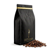 DELUXE SCOOTERS Letters Coffee front bag showing branding and 12 oz benefit