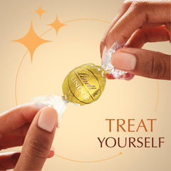 Hand holding a Lindt LINDOR truffle for size perspective and portion benefit