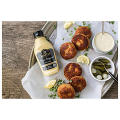 Maille Dijon being spread on a sandwich to add tangy flavor and balance