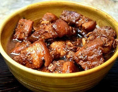 Mama Sita's prepared adobo sauce poured into bowl, rich color and ready to serve