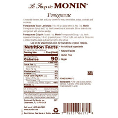 Monin pomegranate syrup poured into glass with splash highlighting vibrant color and mixability