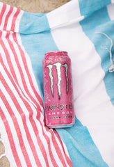 Monster Ultra Rosa can on a picnic table outdoors suggesting refreshing energy