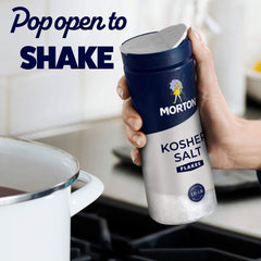 Hand sprinkling Morton shaker onto food demonstrating precise seasoning control