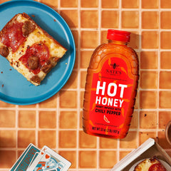 Nate's Honey poured on pizza in lifestyle shot demonstrating sweet-heat enhancement