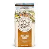 New England Coffee front bag showing hazelnut crème label and net weight, showcases flavor