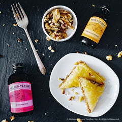 Pouring Nielsen-Massey Rose Water into a mixing bowl to add precise, delicate floral flavor