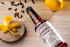 Peychaud's bottle being dashed into cocktail for balanced flavor benefit