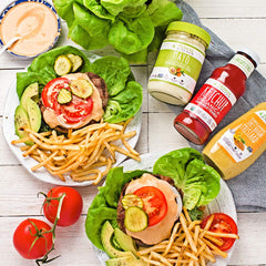 Primal Kitchen two bottles next to burger, convenient two-pack for families