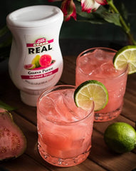 Reàl Infused Exotics syrup being poured into a cocktail, adding tropical guava flavor to drinks