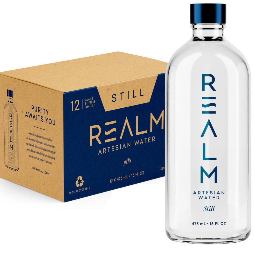 REALM Artesian Water front packaging showing 12-pack glass bottles and premium branding
