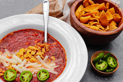 Riega seasoning sprinkled on cooked chicken tacos for bold Tex‑Mex flavor boost