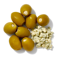 Roland Foods olives skewered in a martini glass as a cocktail garnish, demonstrating serving suggestion