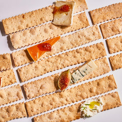 Rustic Bakery baker removing handmade flatbreads from oven, showing small-batch craft