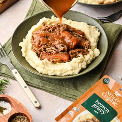 Simply Organic gravy poured over mashed potatoes showcasing hearty flavor enhancement