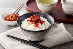 S&B chili oil spooned over noodles delivering umami and crisp garlic topping