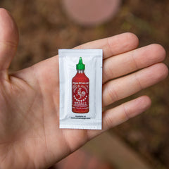 Sriracha2Go sauce being poured onto food showing flavor enhancement