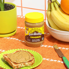 Spoon lifting SunButter to show creamy texture and spreadability