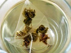 The Tao of Tea hand-rolled jasmine pearls displayed for aroma and quality