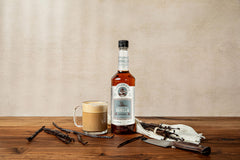 Tippleman's syrup pouring onto iced coffee, adding vanilla flavor without sugar